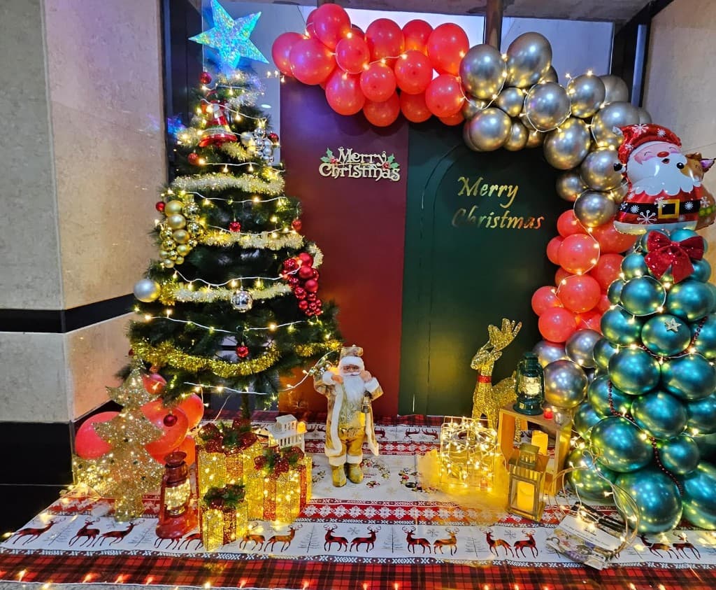 Christmas photo set with tree, balloon arch, Santa figure and gift-box lights in Dubai