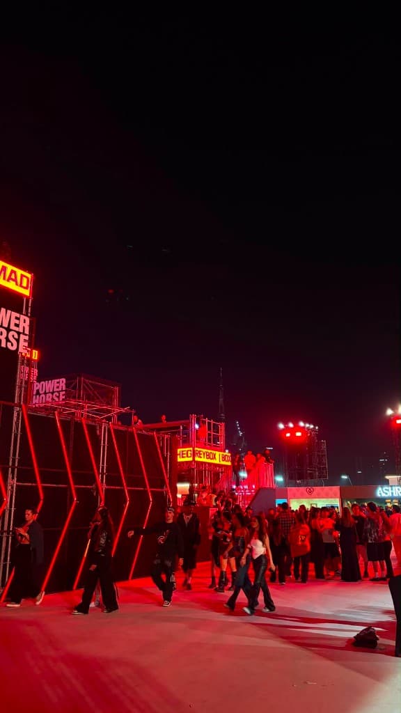 Night brand activation in Dubai with red lighting, scaffolding and Burj Khalifa on the skyline