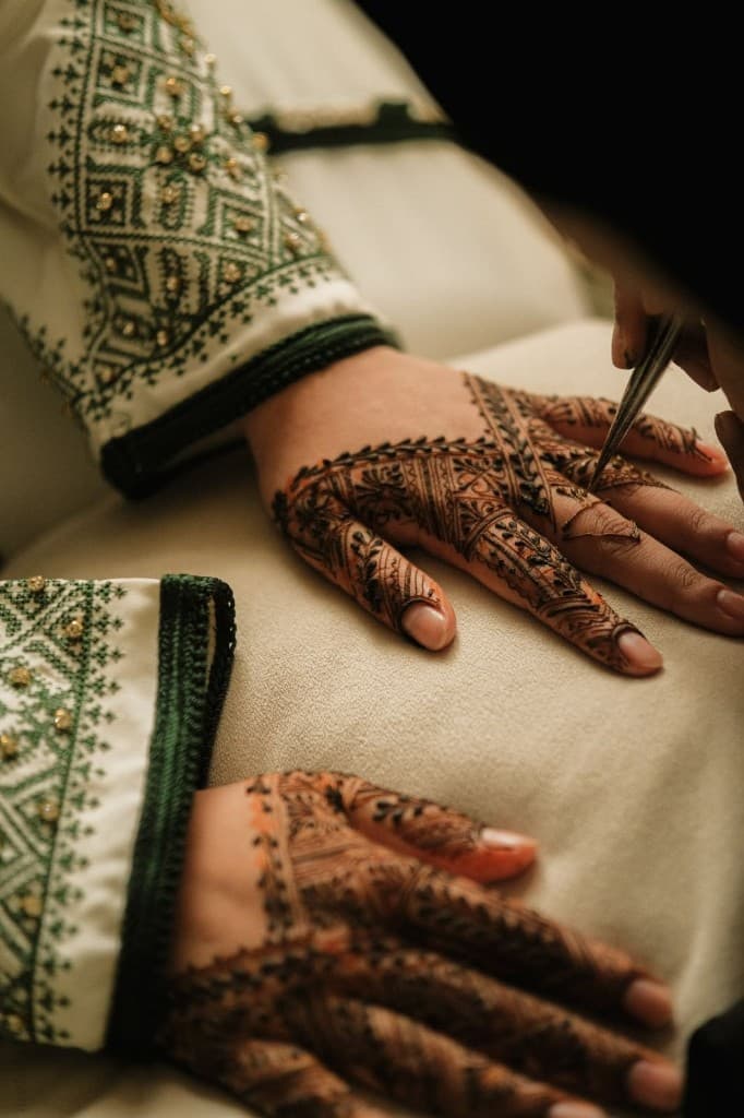 Close-up of henna being applied to a guest’s hands at an Abu Dhabi event