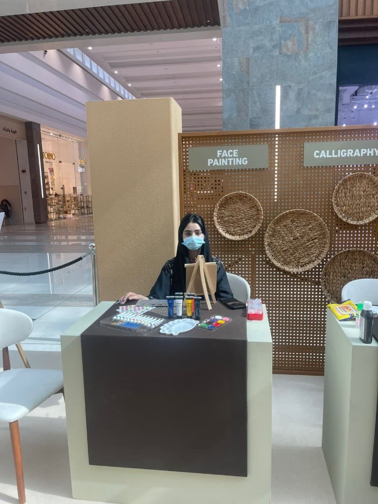 Combined face painting and calligraphy booth with wooden lattice screen in an Abu Dhabi mall